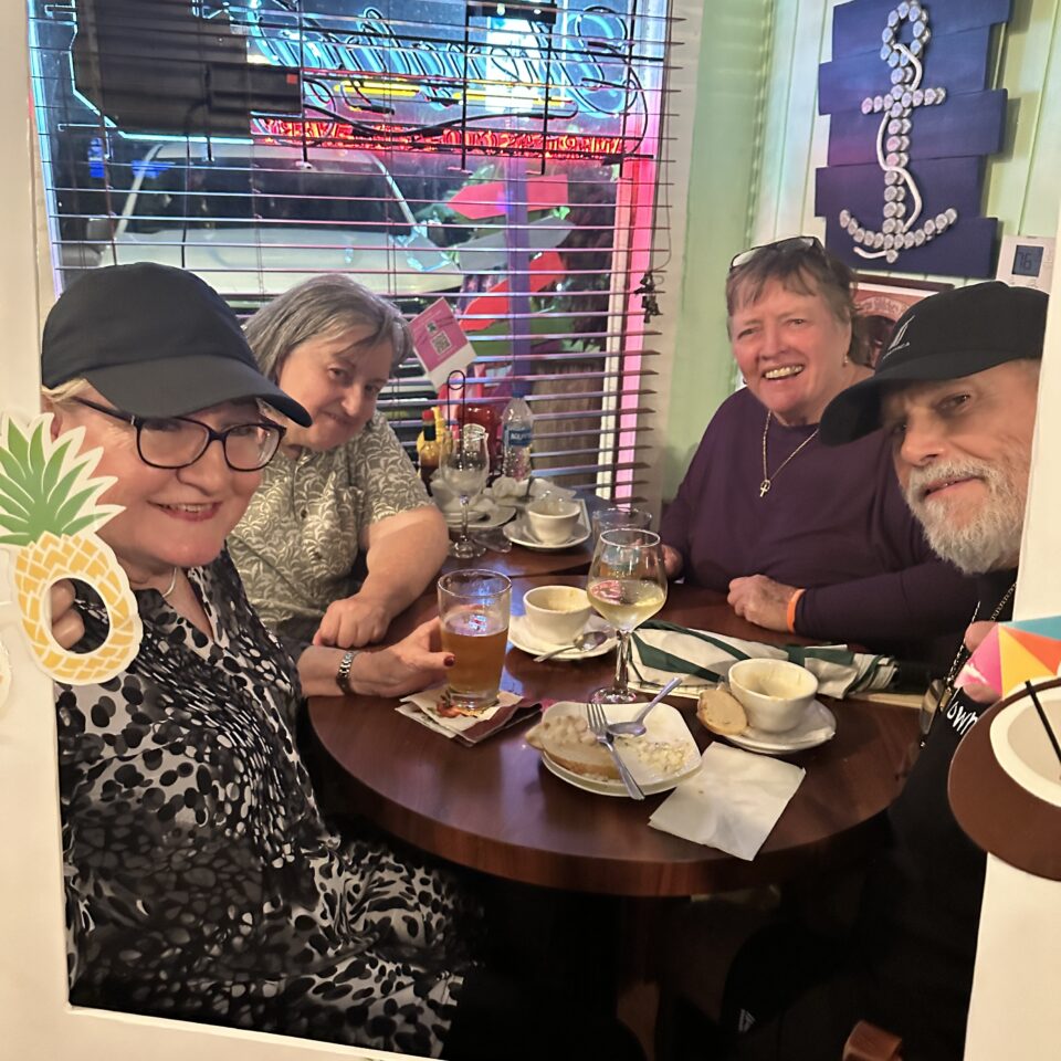 Four guests smiling around a restaurant table