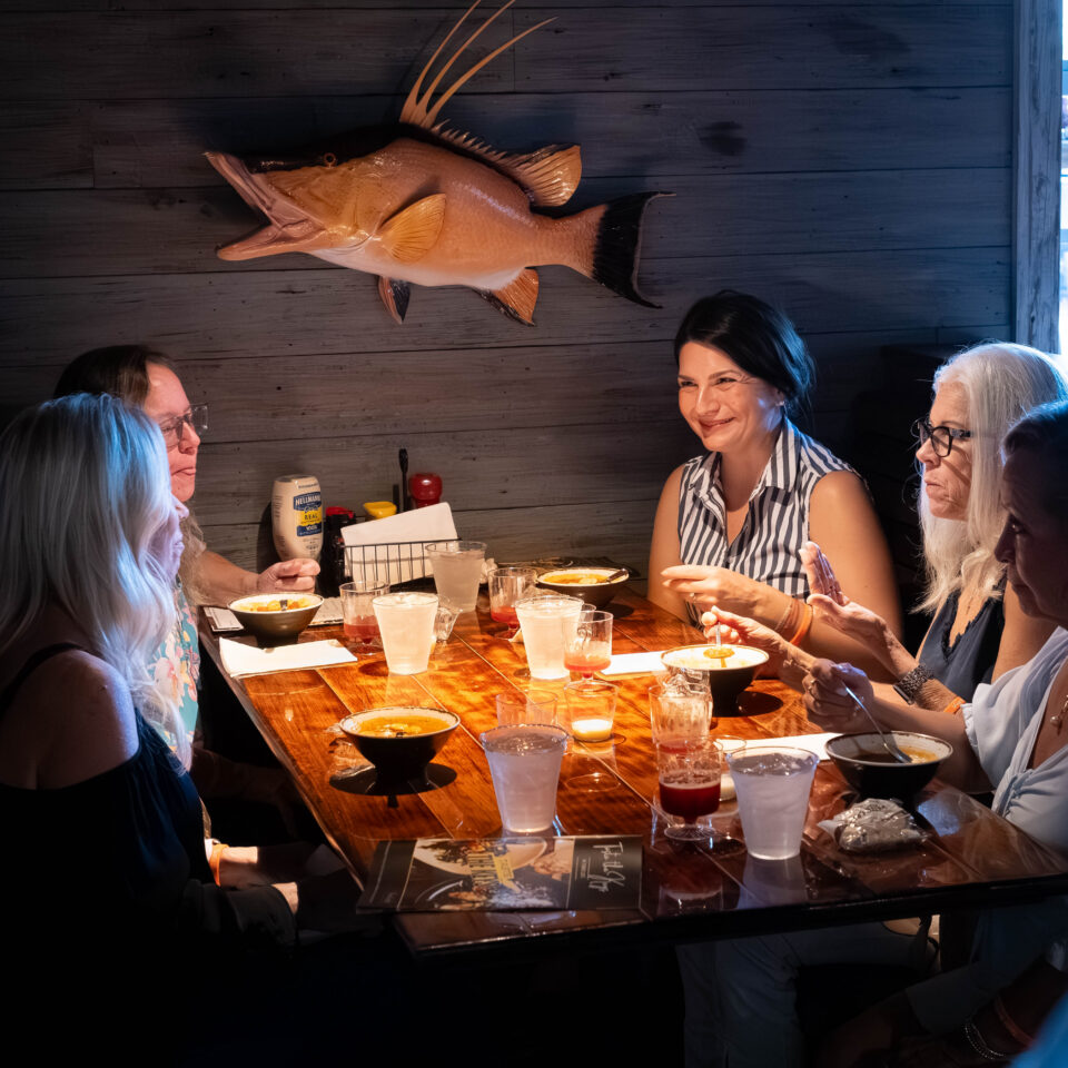 Guests sharing plates at a table beneath a mounted hogfish