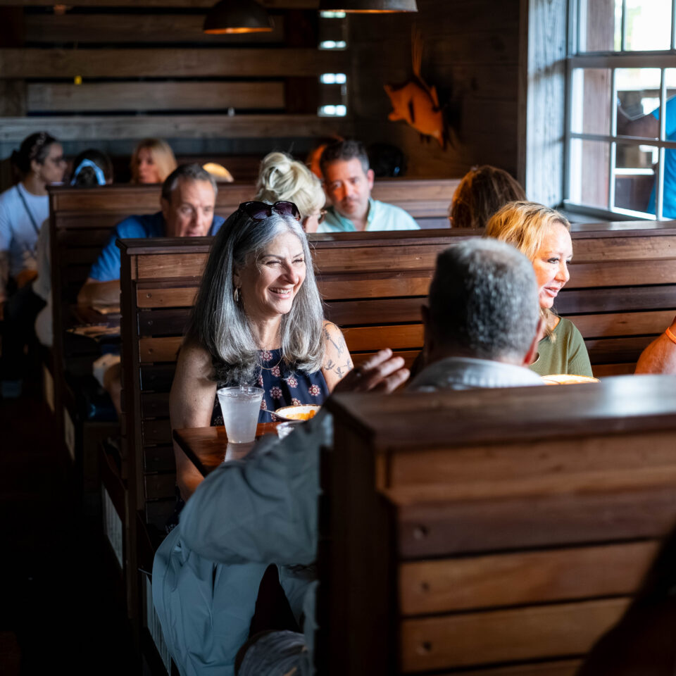 Guests smiling in wooden booths at a restaurant stop