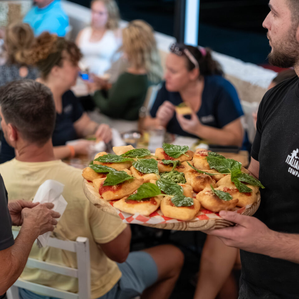 Server offering a platter of bruschetta to seated guests