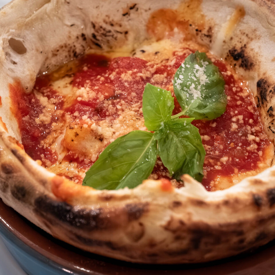 Wood-fired pizza topped with fresh basil